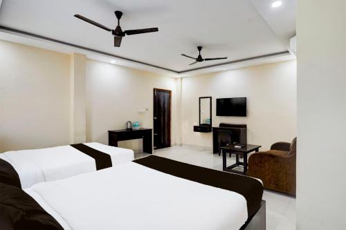 a hotel room with two beds and a tv at Super Collection O Tirumala Road Near Alipiri in Tirupati