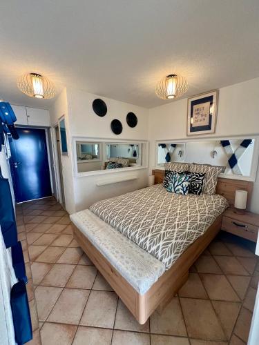 une chambre avec un lit et deux fenêtres dans l'établissement Sea Chic - Naturist, au Cap d'Agde