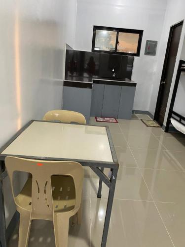 Una mesa y dos sillas en una habitación con televisión. en A & D Hotel & Restobar, en Gasan