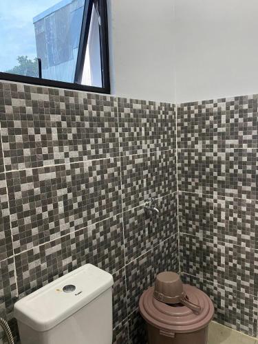 Un baño con inodoro y ventana. en A & D Hotel & Restobar, en Gasan