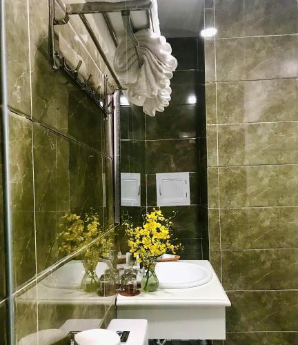 a bathroom with a sink and a toilet with yellow flowers at Cozy 86 Homestay in Can Tho