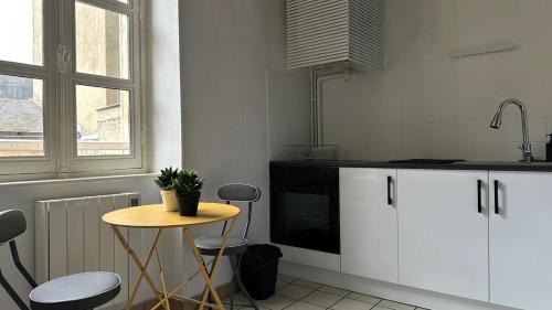 - une cuisine avec une petite table et un évier dans l'établissement Bel appartement proche gare, à Nevers