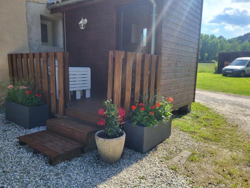a wooden bench sitting next to a house with flowers at Gite le Meillonais in Le Nizan
