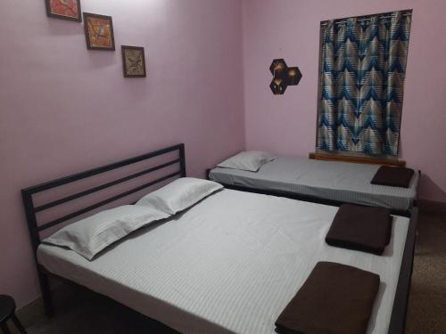 two twin beds in a room with a window at Bubble Beds in Kolkata