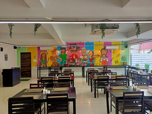 a dining room with tables and a colorful wall at Hotel Grand Continent - HiTec City, Laxmi Cyber City, Hyderabad in Hyderabad
