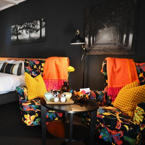 a living room with a couch and a table at The Oriana Orange - Retro Hotel & Resort in Orange