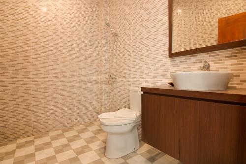 a bathroom with a white toilet and a sink at Diva Lombok Resort in Senggigi 