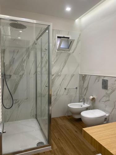 a bathroom with a shower and a toilet and a sink at Muragie del Castello B&B in Trani