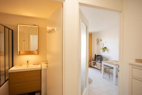 une salle de bain avec un lavabo et un miroir dans l'établissement Sous le Soleil, à Fréjus