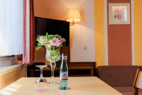 a bottle of wine and two glasses on a table at Landgasthof zur Linde in Heimbuchenthal