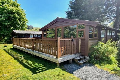 a large wooden cabin in a yard at Cosy log cabin in Snowdonia 19 in Trawsfynydd