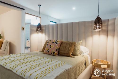 a bedroom with a bed with a large headboard at 202 Arje Suites Campestre by Alegría Housing in Las Pilas