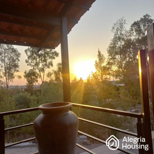 a large vase sitting on a porch with the sunset at 204 Arje Suites Campestre by Alegría Housing in Las Pilas