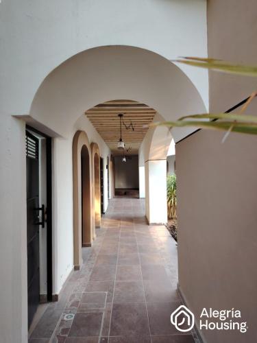 an empty hallway of a building with an archway at 202 Arje Suites Campestre by Alegría Housing in Las Pilas