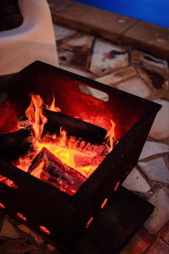a fire in a grill with flames in it at The Oriana Orange - Retro Hotel & Resort in Orange