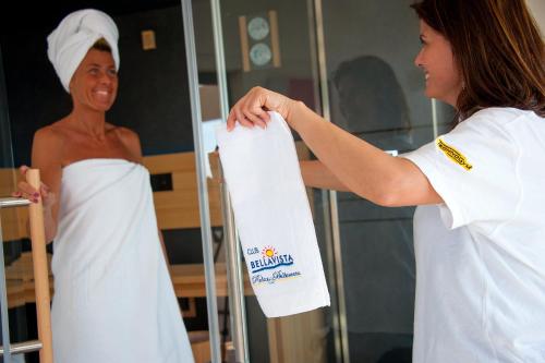 a woman holding a towel in front of a mirror at Hotel Bellavista Club-Caroli Hotels in Gallipoli