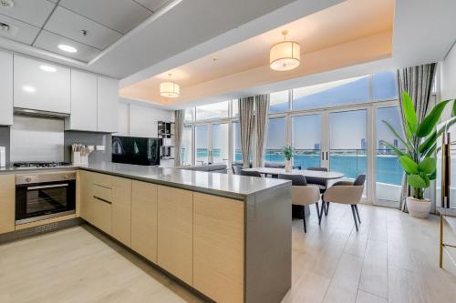 an open kitchen and dining room with a view of the ocean at GlobalStay Azizi Mina Beachfront Apartments Palm Jumeirah in Dubai