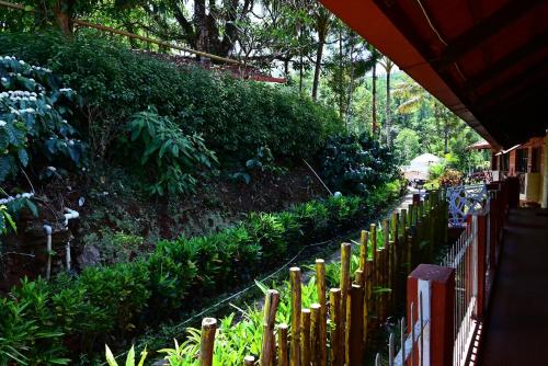 a fence in front of a garden with plants at Aayana Valley in Chikmagalur