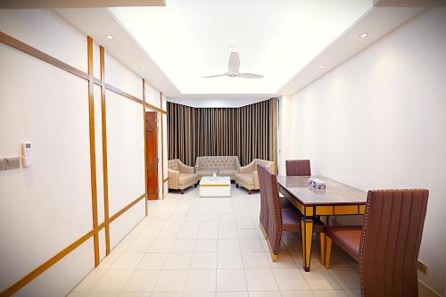 a living room with a table and a couch at Tourister Bd Ltd in Dhaka