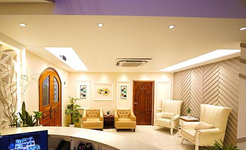 a lobby with chairs and a tv in a building at Tourister Bd Ltd in Dhaka