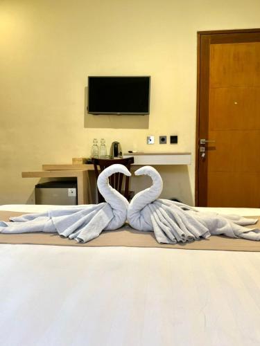 a bed with two swans forming a heart at Srikrisna in Seminyak