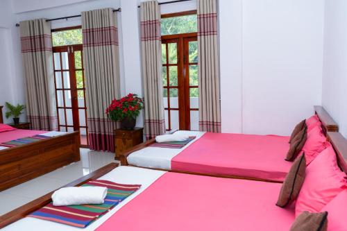 a bedroom with two beds and two windows at Flower Top Ella in Ella