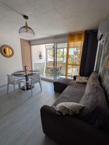 un salon avec un canapé et une table dans l'établissement Appartement au pied de la plage - Saint cyprien, à Saint-Cyprien