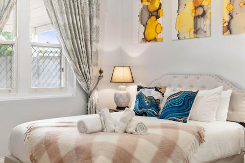 a white bedroom with a bed with towels on it at Stylish 2 Bedroom Unit Close to CBD in Evandale
