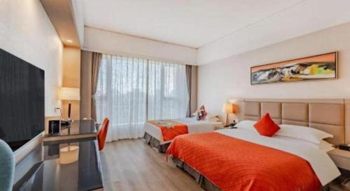 a hotel room with two beds and a desk at Hefei Parkview Hotel in Hefei