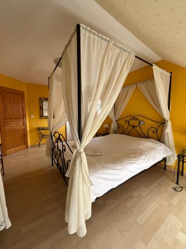 a bedroom with a bed with a canopy at Gîte aux 2 vignes - Grande maison idéale en famille ou entre amis - Animaux acceptés in Kientzheim