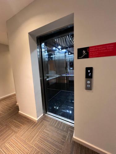 a door in a building with a sign on a wall at Havona Hotel - CIQ Johor Bahru - Self Check-In in Johor Bahru