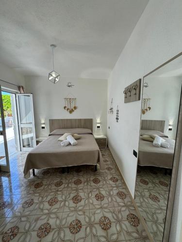 a bedroom with two beds and a large mirror at Villa Chiena Forio in Ischia