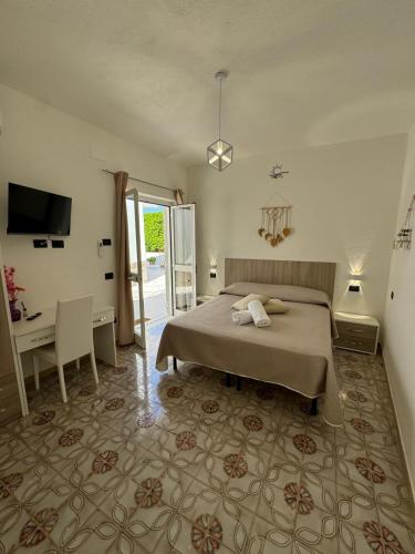a bedroom with a bed and a desk and a television at Villa Chiena Forio in Ischia