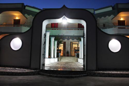 a view of a building with a mirror in front at Hotel Dimitra Sun in Archangelos