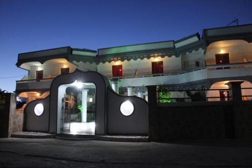 a building with an archway in front of it at night at Hotel Dimitra Sun in Archangelos
