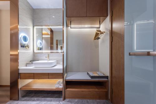 un bagno con lavandino e specchio di Atour X Hotel Beijing Haidian Sijiqing a Pechino
