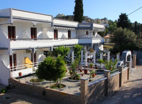 a building with potted trees in front of it at Hotel Dimitra Sun in Archangelos