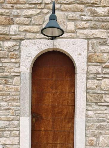 a light above a wooden door in a brick building at La Locanda del Mugnaio in Roseto Valfortore