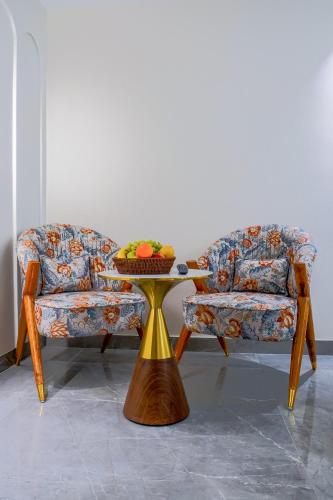 a couch and a table with a bowl of fruit on it at Hotel Horizon By Shanti in New Delhi