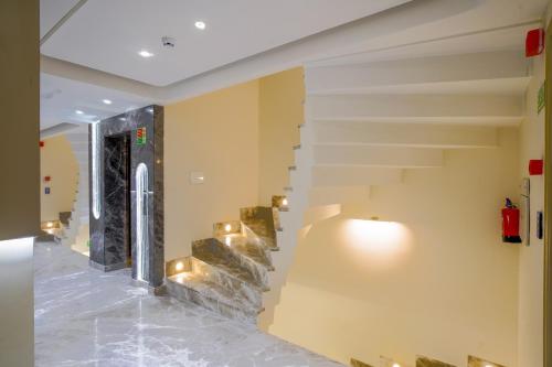 a lobby with a staircase with lights on the wall at Hotel Horizon By Shanti in New Delhi