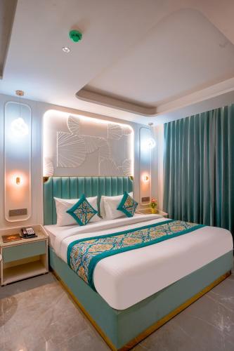 a bedroom with a large bed with blue curtains at Hotel Horizon By Shanti in New Delhi