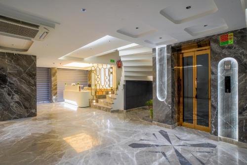 a lobby of a hotel with marble floors and a door at Hotel Horizon By Shanti in New Delhi