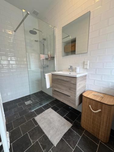 a bathroom with a sink and a shower with a mirror at Barbera Guesthouse Hotel Apartments - Experience local life in the Old Centre in Haarlem