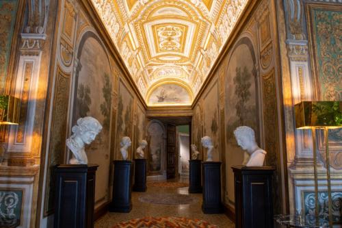 a hallway in a museum with statues on the walls at Palazzo Shedir - The Leading Hotels of the World in Rome