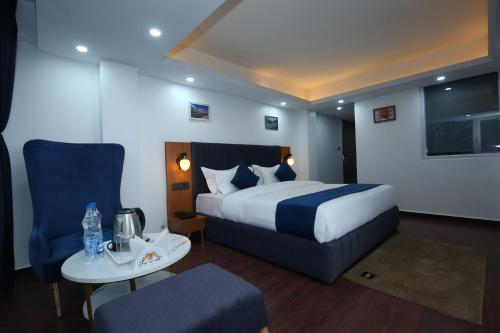 a hotel room with a bed and a table and chair at The White Mountain View Kufri in Kūfrī