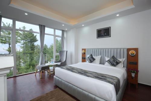 a bedroom with a large bed and a large window at The Snow Castle Kufri - A hidden gem in KUFRI in Shimla