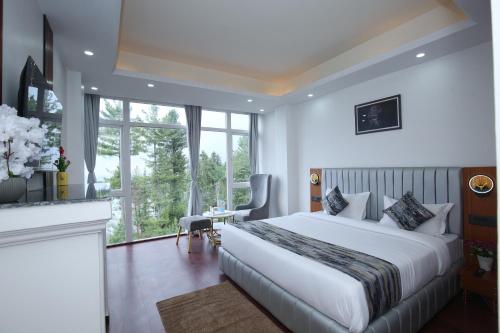 a bedroom with a large white bed and a desk at The Snow Castle Kufri - A hidden gem in KUFRI in Shimla