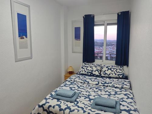 a bedroom with a bed with two pillows and a window at La Bella Vista in Puerto de Mazarrón