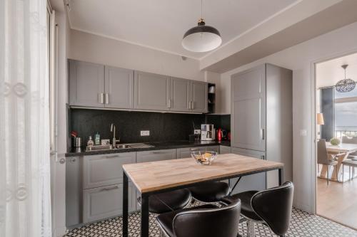 une cuisine avec une table en bois et des chaises noires dans l'établissement Paquebot - face port - mer - parking, à Saint-Nazaire