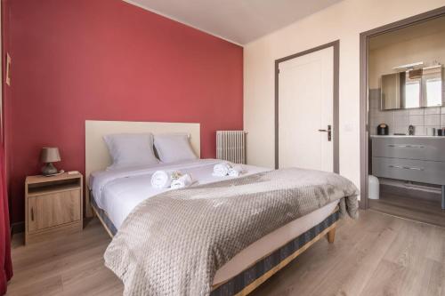 une chambre avec un lit blanc et un mur rouge dans l'établissement Paquebot - face port - mer - parking, à Saint-Nazaire